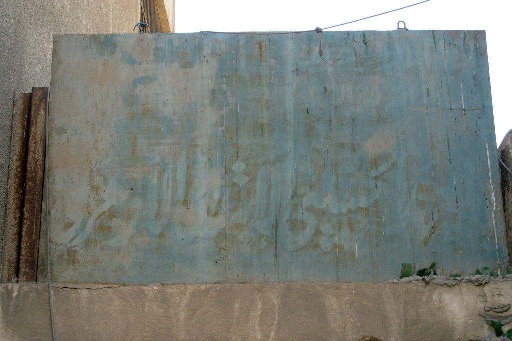 Faded sign of the primary school, E. side